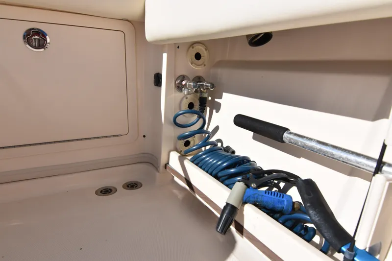 Slide: The Image of 2017 Grady-White Express 330 boat storage compartment with coiled hose and tools. - 34