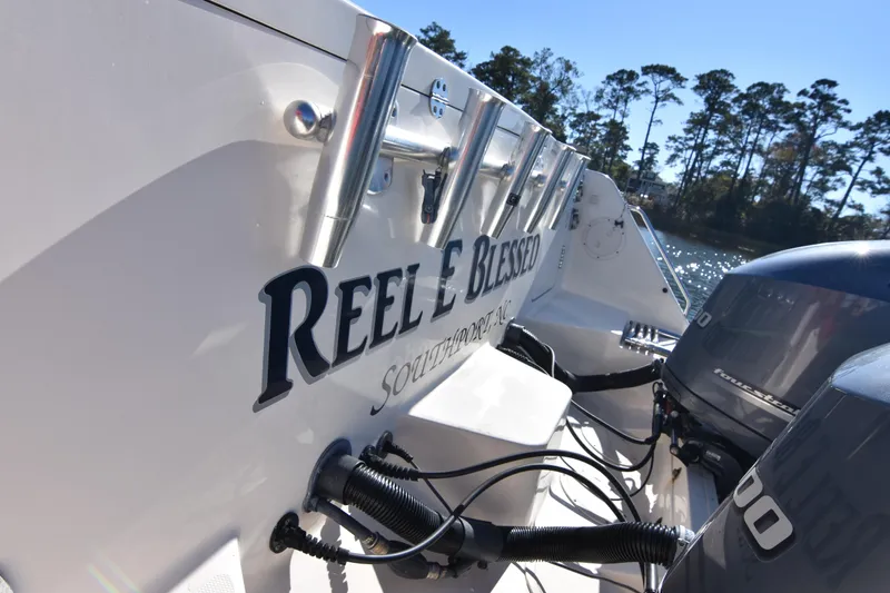 Slide: The Image of 2017 Grady-White Express 330 boat with "Reel Blessed" name, docked near trees. - 35