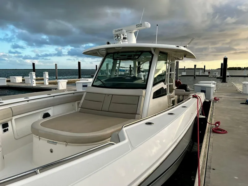 Slide: The Image of 2019 Boston Whaler 380 Outrage docked, showcasing sleek design and spacious seating. - 14