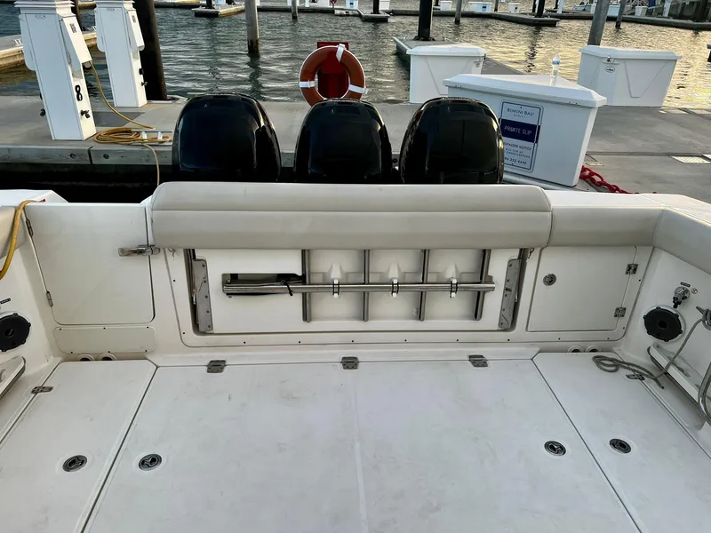 Slide: The Image of 2019 Boston Whaler 380 Outrage boat deck with triple outboard engines at dock. - 18