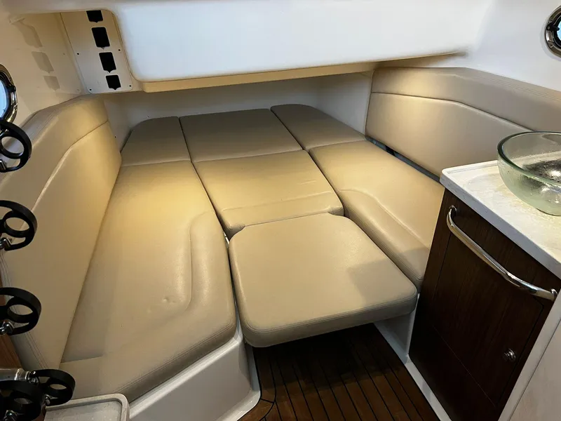 Slide: The Image of 2019 Boston Whaler 380 Outrage cabin interior with beige seating and wooden accents. - 22