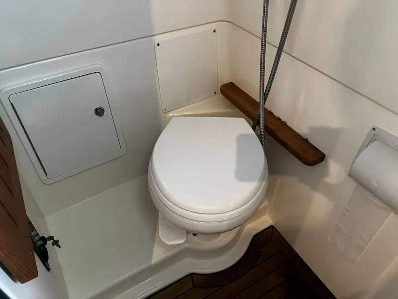 Slide: The Image of 2019 Boston Whaler 380 Outrage boat bathroom with toilet and wooden accents. - 25