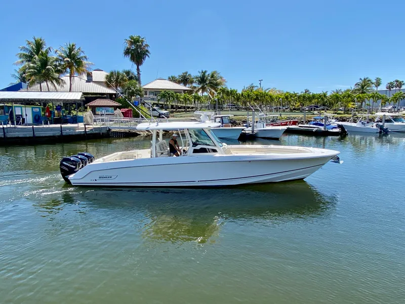 Slide: The Image of 2019 Boston Whaler 380 Outrage boat cruising in a sunny marina setting. - 3