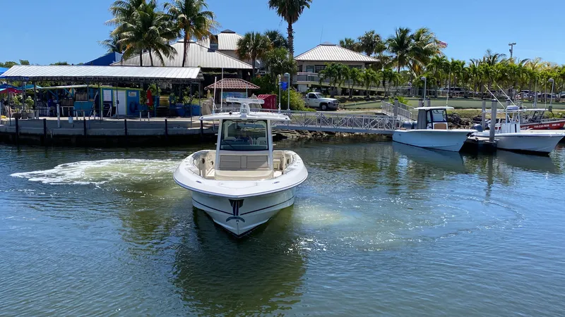 Slide: The Image of 2019 Boston Whaler 380 Outrage boat navigating near a tropical marina. - 6