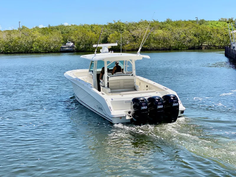Slide: The Image of 2019 Boston Whaler 380 Outrage boat cruising on a calm waterway. - 9