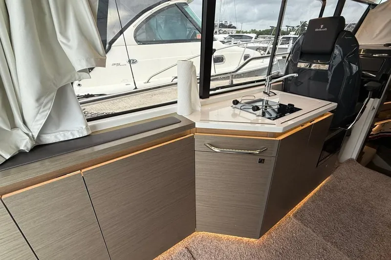 Slide: The Image of Interior of 2023 Wellcraft 355 boat with modern kitchenette and seating. - 10