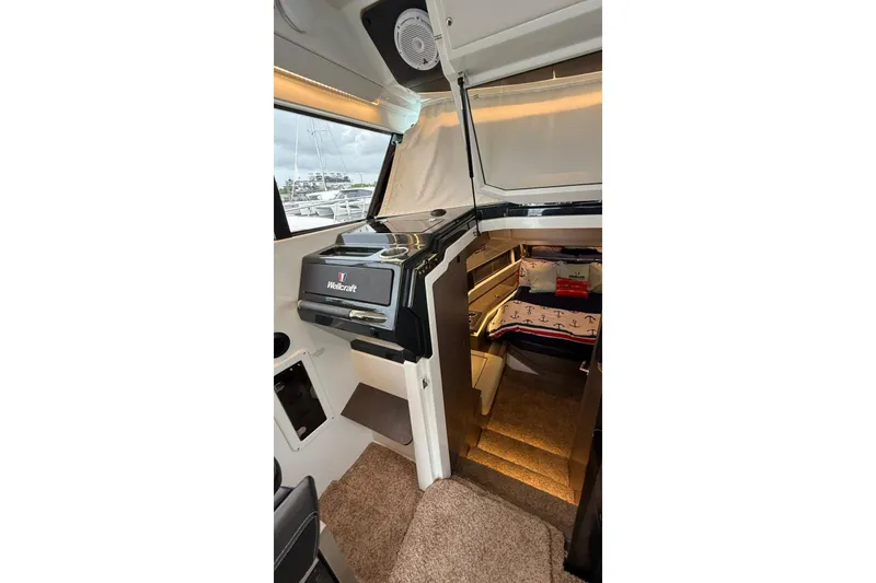 Slide: The Image of 2023 Wellcraft 355 cabin interior with cozy bedding and modern design. - 13