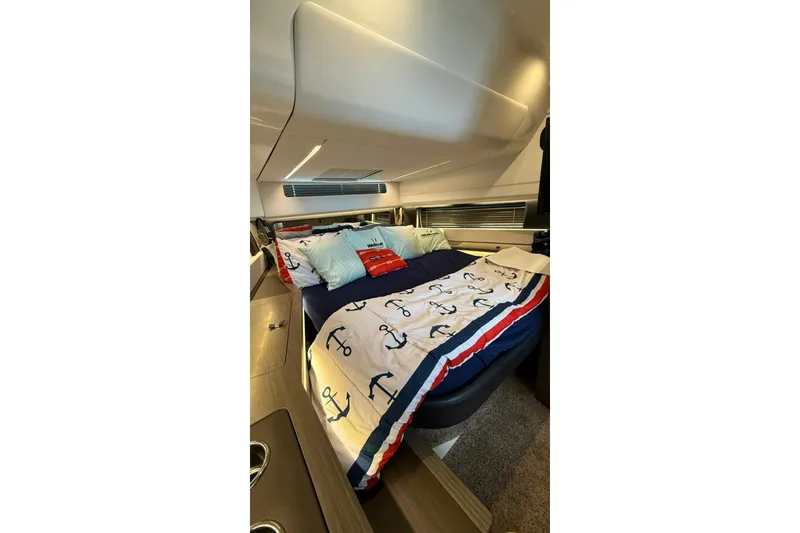 Slide: The Image of Luxurious cabin interior of 2023 Wellcraft 355 boat with nautical-themed bedding. - 15