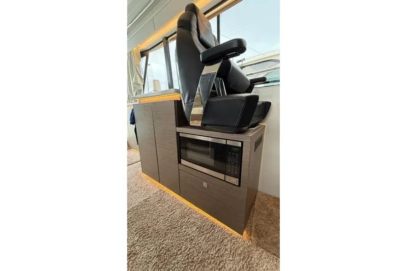 Slide: The Image of Interior of 2023 Wellcraft 355 boat featuring a modern seat and built-in microwave. - 17