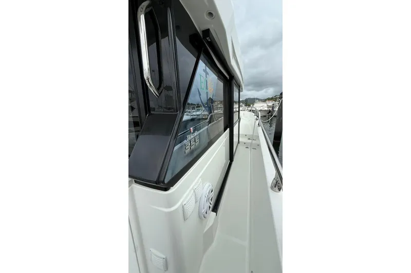 Slide: The Image of 2023 Wellcraft 355 boat side view, docked at marina under cloudy sky. - 5