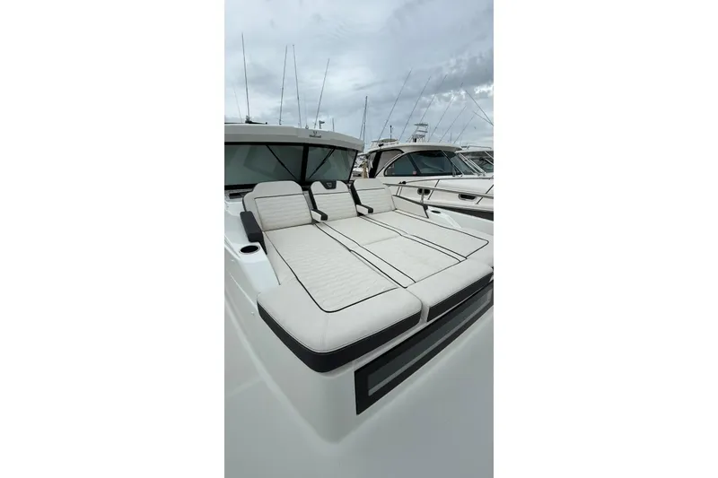 Slide: The Image of 2023 Wellcraft 355 yacht with luxurious deck seating, docked at marina. - 6