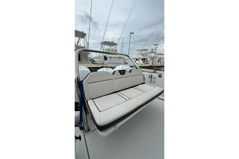 Slide: The Image of 2023 Wellcraft 355 boat interior with cushioned seating at marina. - 7