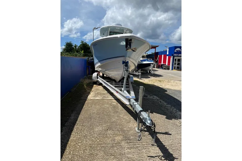 The Image of 2024 Boston Whaler 280 Outrage boat on trailer under cloudy sky. - 1