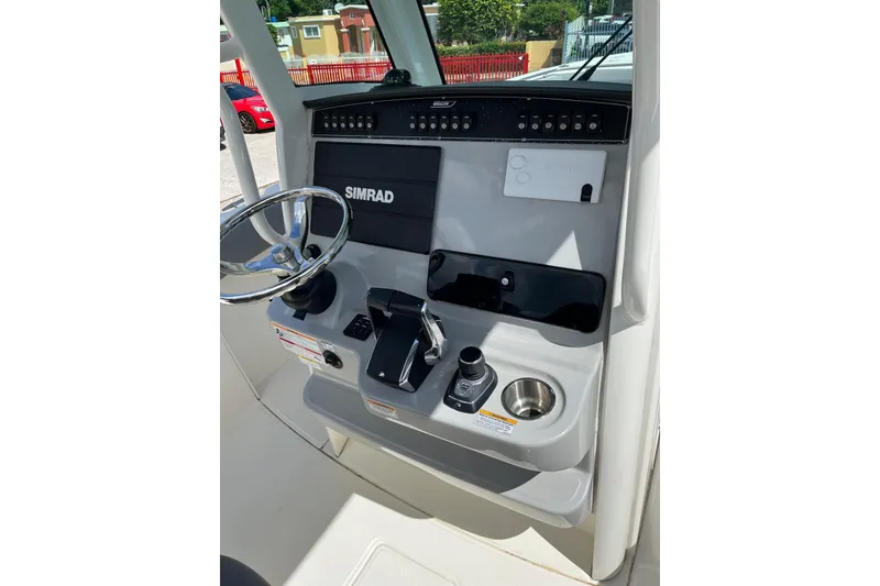 Slide: The Image of 2024 Boston Whaler 280 Outrage helm with Simrad electronics and modern controls. - 4