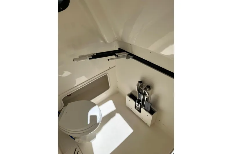 Slide: The Image of 2024 Boston Whaler 280 Outrage interior cabin with toilet and storage. - 6