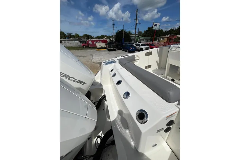 Slide: The Image of 2024 Boston Whaler 280 Outrage boat with Mercury engines, docked under a clear sky. - 7