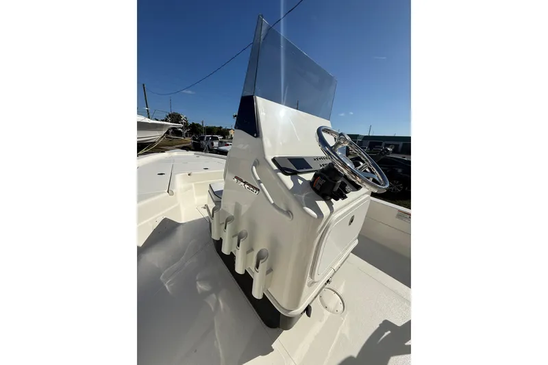 Slide: The Image of 2025 Skeeter SX221 boat console with steering wheel and rod holders. - 14