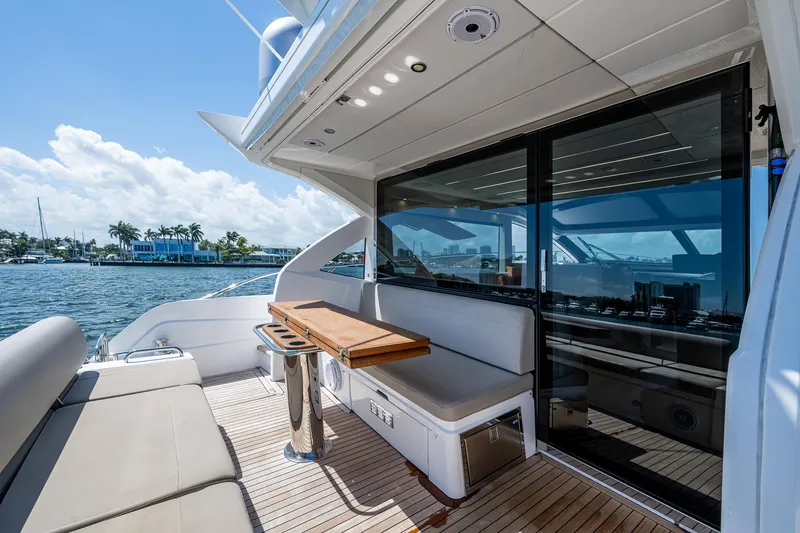 Slide: The Image of 2019 Sunseeker Predator 50 yacht deck with seating, table, and ocean view. - 18