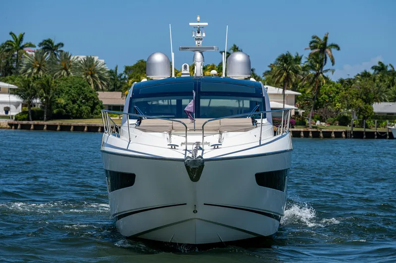 Slide: The Image of 2019 Sunseeker Predator 50 yacht cruising on a sunny day, surrounded by palm trees. - 2
