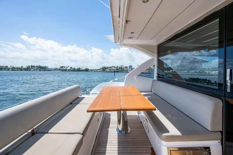 Slide: The Image of Luxurious Sunseeker Predator 50 yacht deck with seating and table, overlooking serene waters. - 23