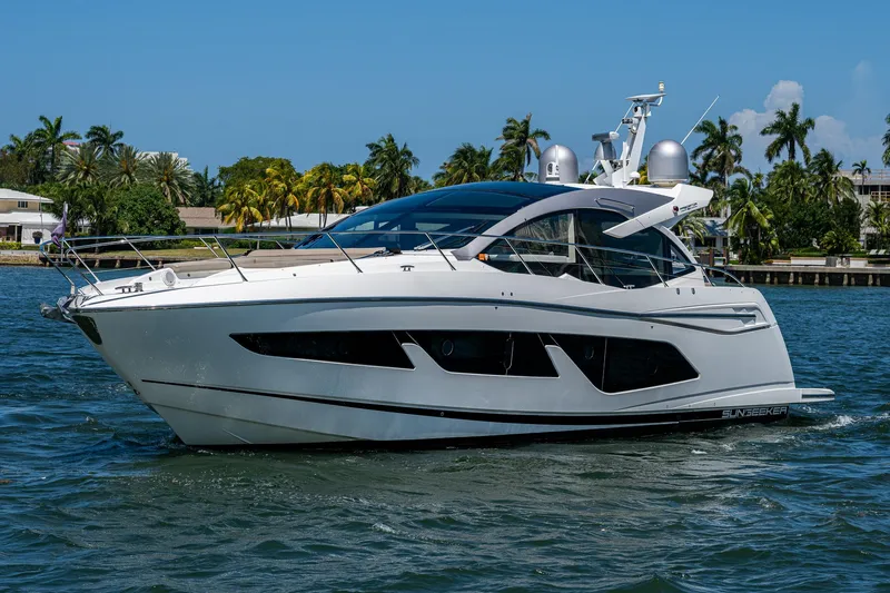 Slide: The Image of 2019 Sunseeker Predator 50 yacht cruising on a sunny day, surrounded by palm trees. - 3