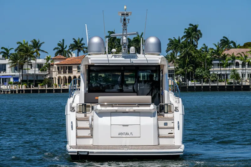Slide: The Image of 2019 Sunseeker Predator 50 yacht on water, rear view, with palm trees in background. - 7