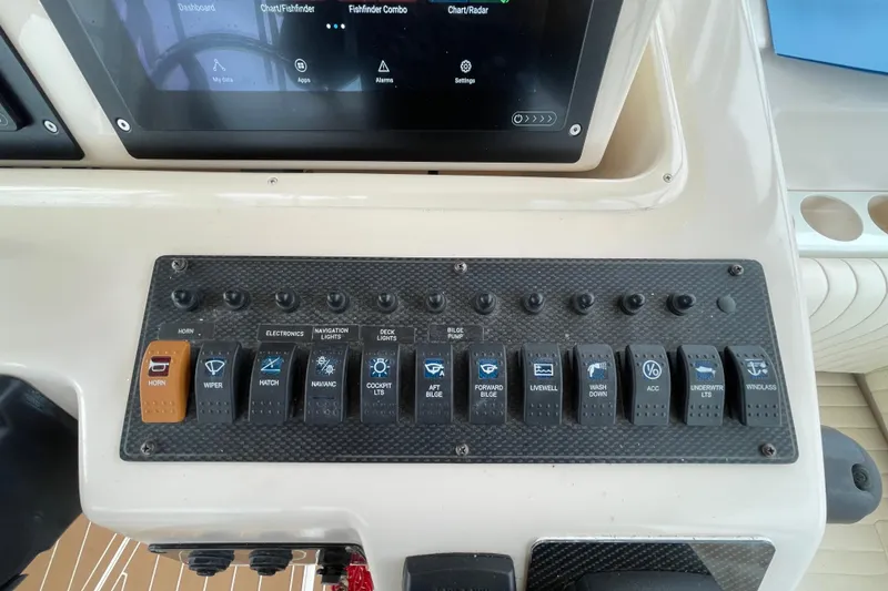 Slide: The Image of Control panel of a 2007 Grady-White Express 330 boat with labeled switches. - 13
