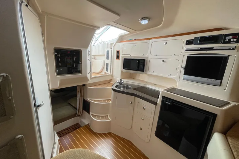 Slide: The Image of 2007 Grady-White Express 330 cabin interior with kitchenette, microwave, and compact appliances. - 25