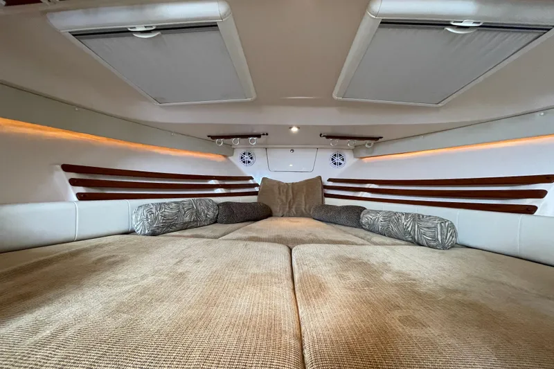 Slide: The Image of Interior cabin of 2007 Grady-White Express 330 boat, featuring cozy bedding and ambient lighting. - 28