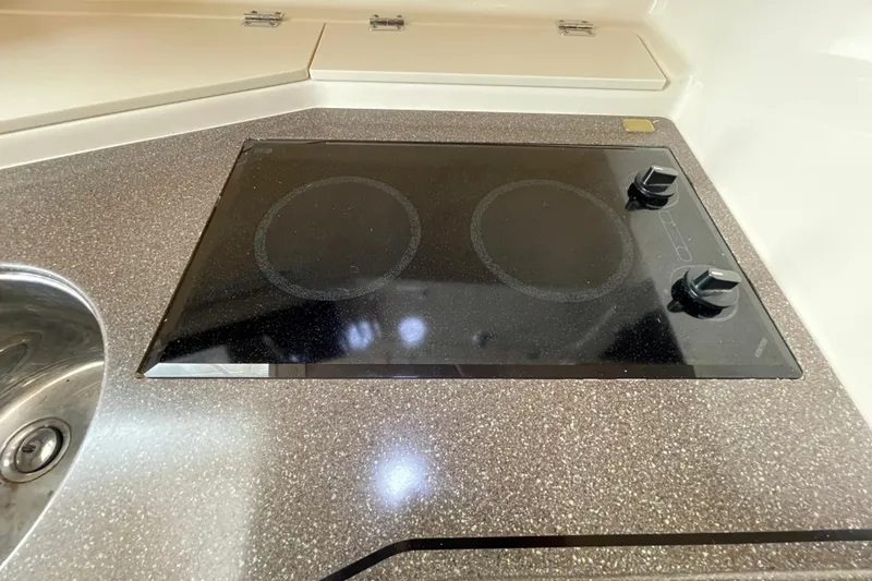 Slide: The Image of 2007 Grady-White Express 330 boat kitchen with electric stovetop and sink. - 35