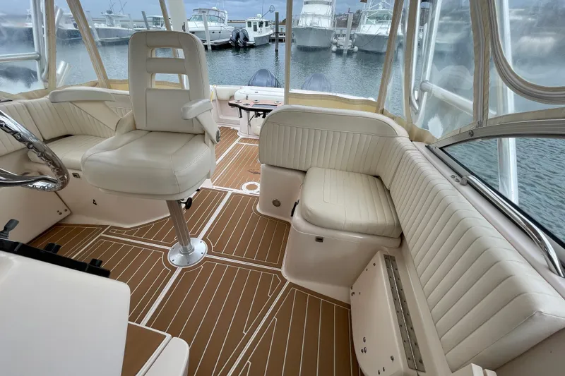 Slide: The Image of 2007 Grady-White Express 330 boat interior with white seating and wood-patterned flooring. - 8