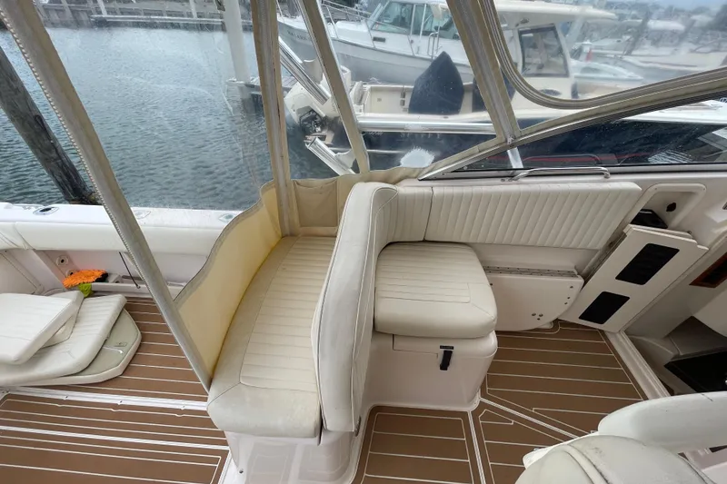 Slide: The Image of 2007 Grady-White Express 330 boat interior with white seating and wooden flooring. - 9