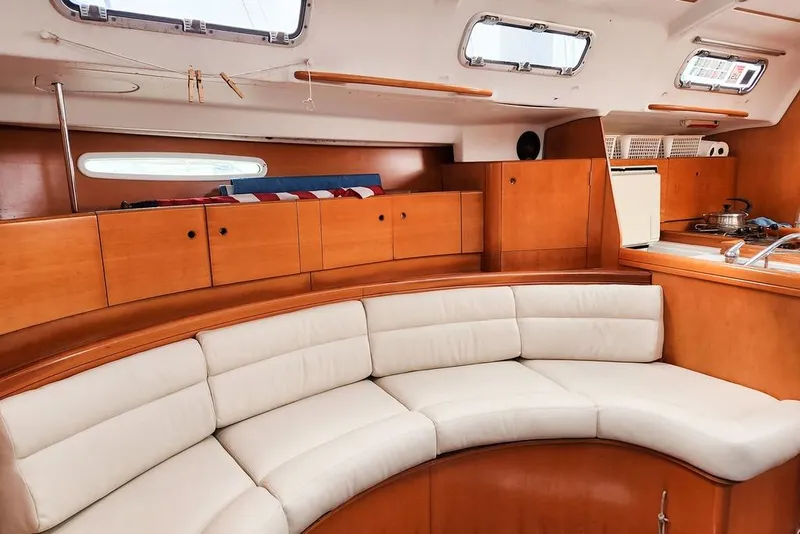 Slide: The Image of Interior of 2005 Beneteau First 44.7 yacht with curved seating and wooden cabinetry. - 23