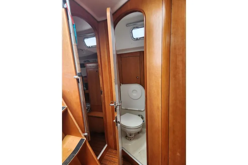 Slide: The Image of 2005 Beneteau First 44.7 yacht interior with wooden finish and compact bathroom. - 25