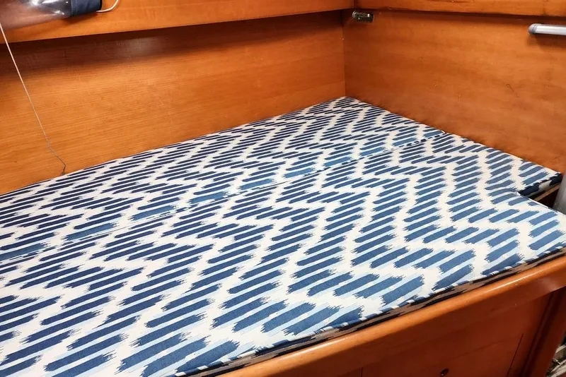 Slide: The Image of Cushioned bed in 2005 Beneteau First 44.7 yacht with blue patterned fabric. - 28