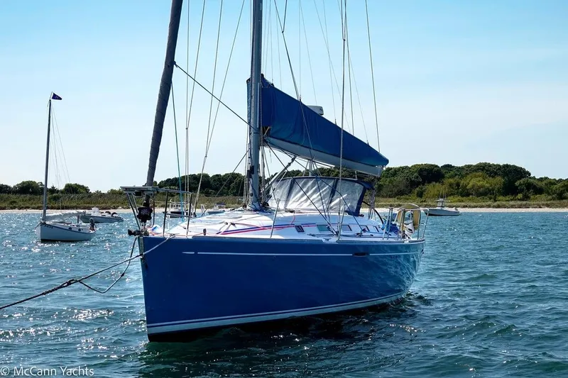 Slide: The Image of 2005 Beneteau First 44.7 sailboat anchored in calm waters, clear sky background. - 7