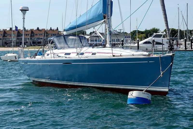 Slide: The Image of 2005 Beneteau First 44.7 sailboat moored in a marina, blue hull, clear day. - 9