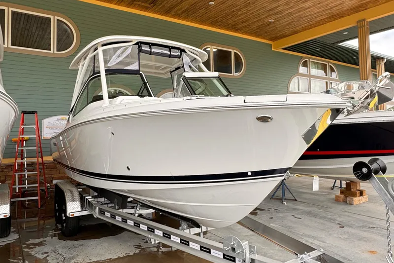 Slide: The Image of 2024 Pursuit DC 246 Dual Console boat on trailer, displayed indoors. - 1
