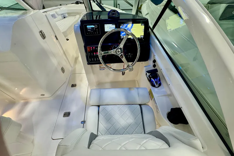 Slide: The Image of 2024 Pursuit DC 246 Dual Console boat interior with modern dashboard and steering wheel. - 15