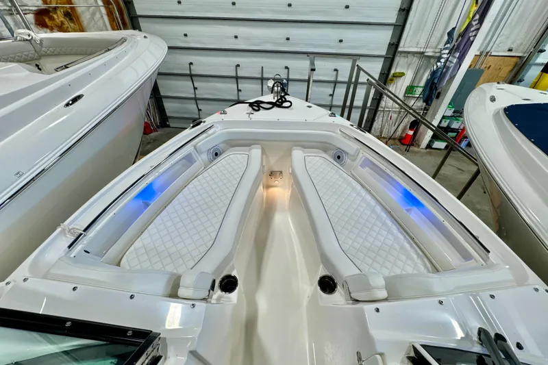 Slide: The Image of 2024 Pursuit DC 246 Dual Console boat interior with cushioned seating and ambient lighting. - 23