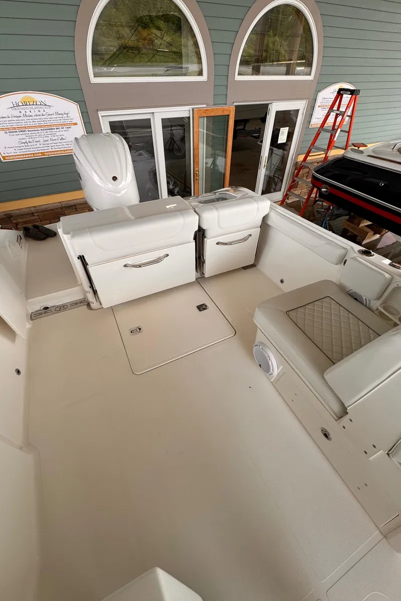 Slide: The Image of 2024 Pursuit DC 246 Dual Console boat interior with seating and storage compartments. - 29