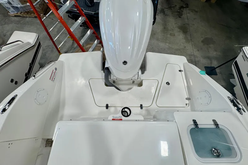 Slide: The Image of 2024 Pursuit DC 246 Dual Console boat deck with engine and storage compartments. - 3