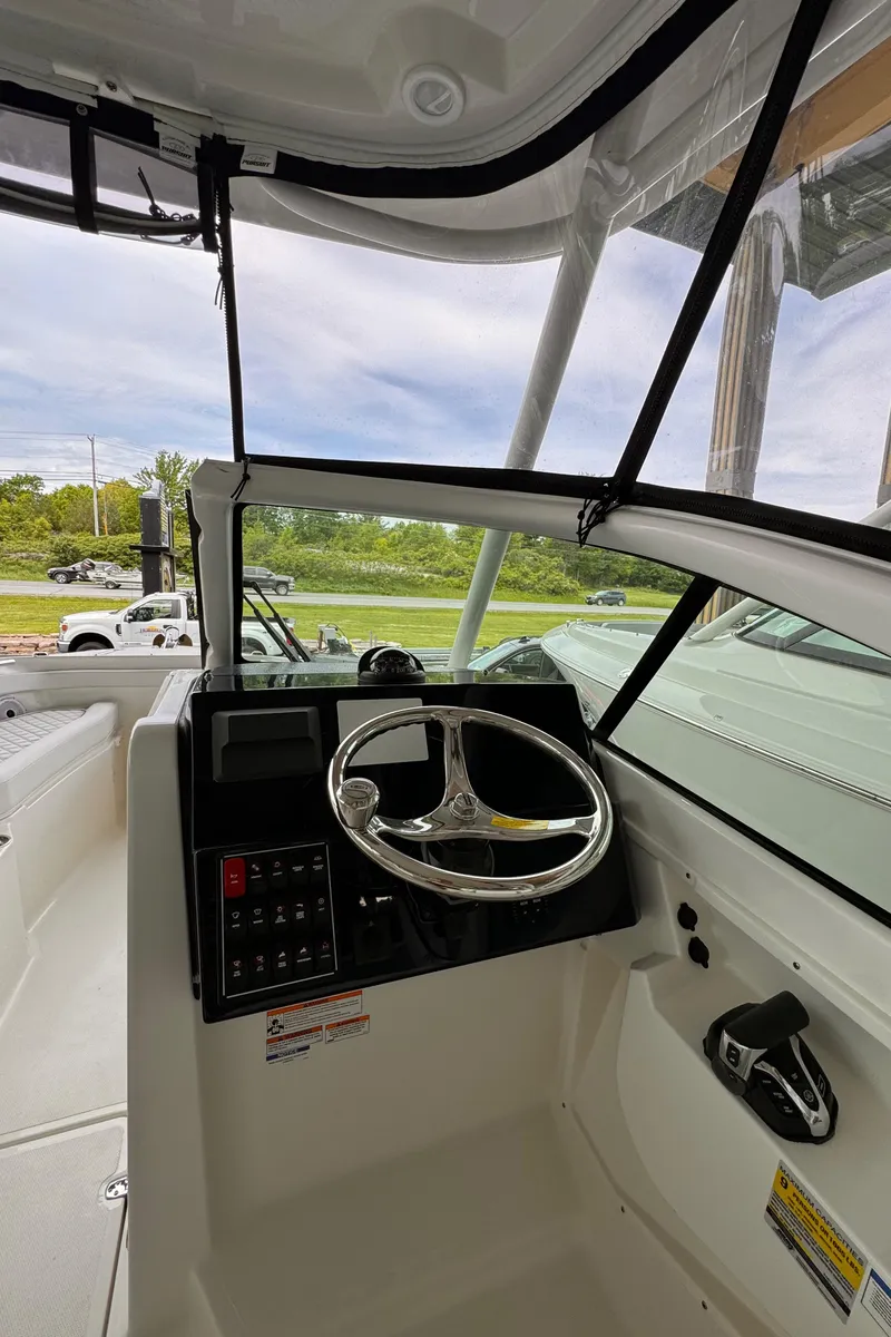 Slide: The Image of 2024 Pursuit DC 246 Dual Console boat cockpit with steering wheel and control panel. - 35