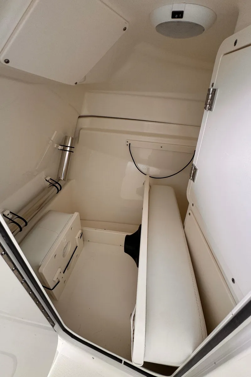 Slide: The Image of 2024 Pursuit DC 246 Dual Console interior cabin with seating and storage. - 38