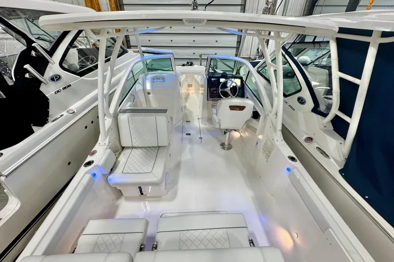Slide: The Image of 2024 Pursuit DC 246 Dual Console boat interior with white seating and modern dashboard. - 4