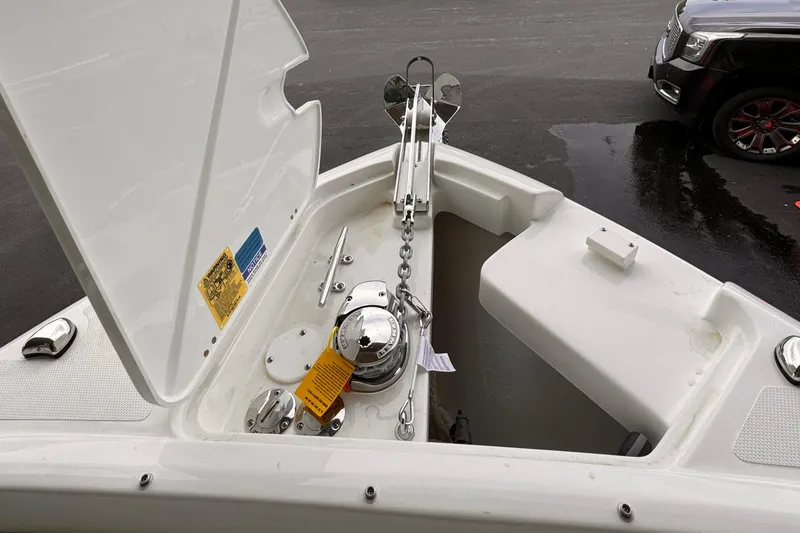 Slide: The Image of 2024 Pursuit DC 246 Dual Console boat anchor compartment with open hatch. - 41