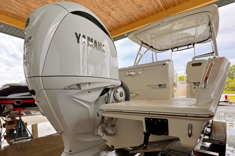 Slide: The Image of 2024 Pursuit DC 246 Dual Console boat with Yamaha engine, showcased in a covered area. - 44