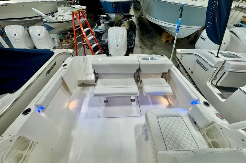 Slide: The Image of 2024 Pursuit DC 246 Dual Console boat interior with white seating and modern design. - 7