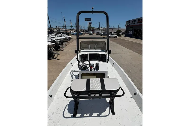 Slide: The Image of 2026 Freedom Boats 21' Commander, center console view, parked outdoors on a sunny day. - 10