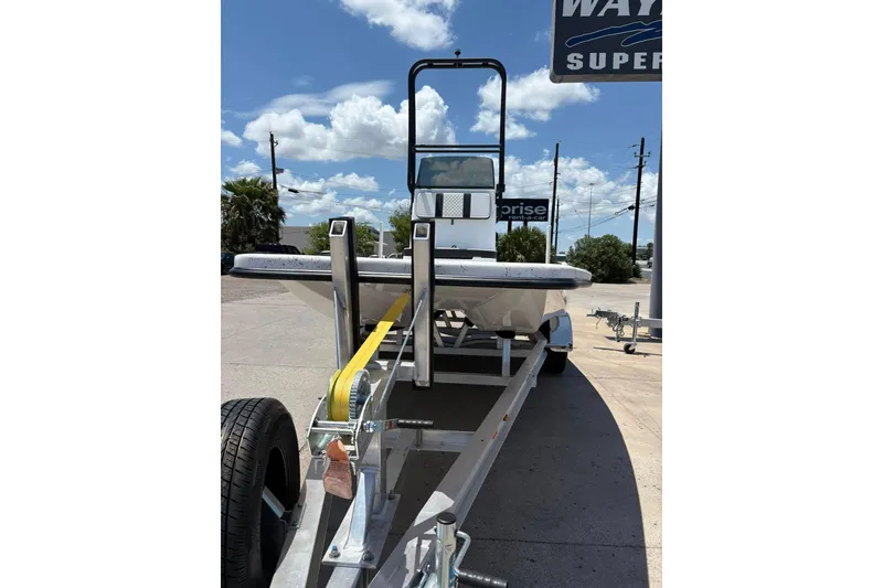 Slide: The Image of 2026 Freedom Boats 21' Commander on trailer under clear blue sky. - 14